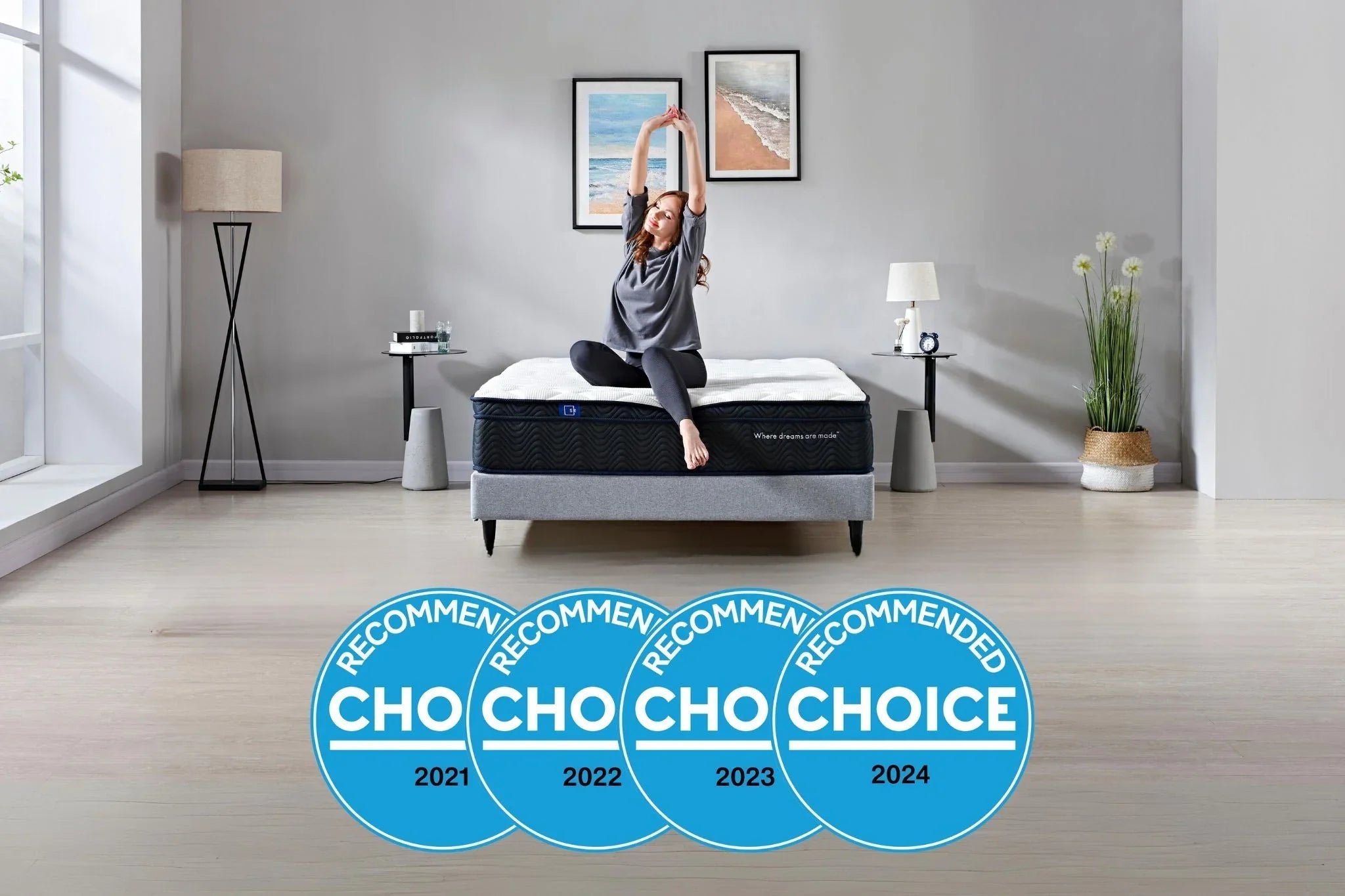 Woman stretching on a modern bed mattress in minimalist bedroom with ocean art and recommended choice awards