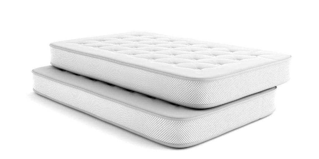 Two white single size mattresses stacked, featuring quilted tops and patterned sides