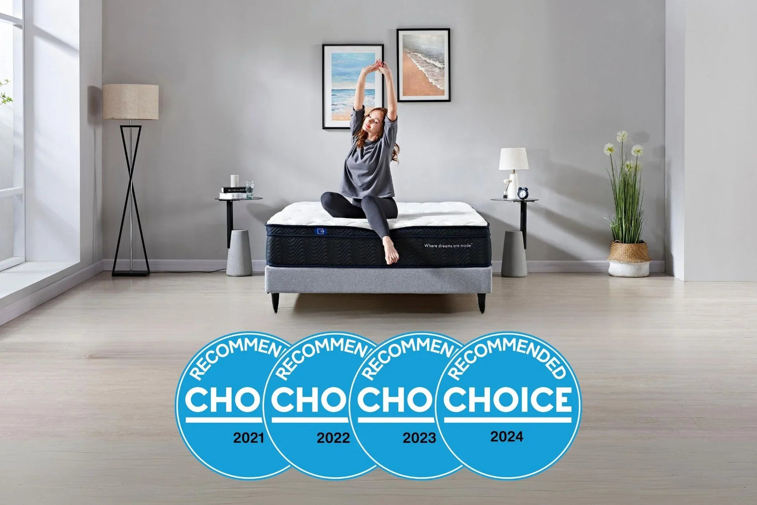 Woman stretching on a modern bed mattress in minimalist bedroom with ocean art and recommended choice awards