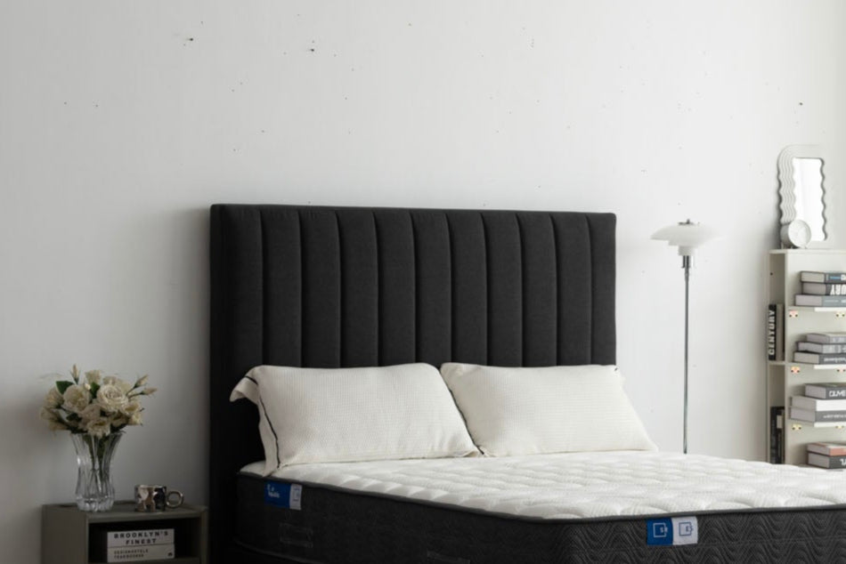 Bedroom with a black bed frame and mattress in a minimalistic room.